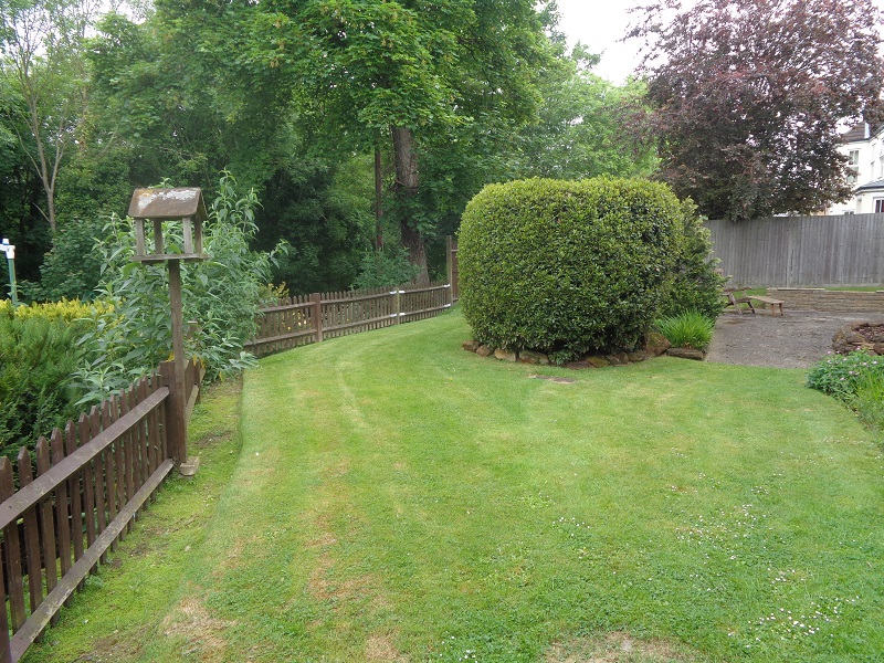 Rosewood Care Home front garden with manicured lawn and mature trees
